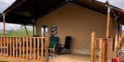 The outside of the tent with a covered deck and chairs