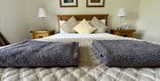 Wooden double bed with a textured throw and coloured pillows