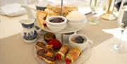 Two‑tier afternoon tea stand with scones, pastries, and small desserts.