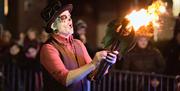 Masked fire juggler