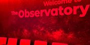 row of chairs against a wall with the signage Welcome to the Observatory