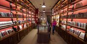 A group explores a beautiful red room with shelves filled with memorabilia relating to Seamus Heaney