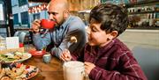 A father and son drinking hot chocolate in a restaurant