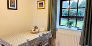 Dining area with table seating beside a large window.