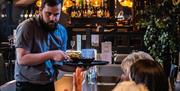 A waiter serving food to customers