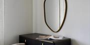Bedroom dressing table with mirror and wall-mounted TV.