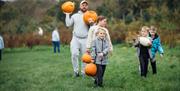 Hallowee'uns: Family holding multiple pumpkins