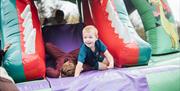 Hallowee'uns: Children sliding down an inflatable bouncy castle slide