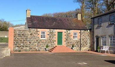 The exterior of a cottage with a green door