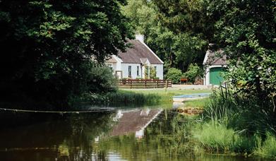 Image of lodge on lakeside with surrounding greenery