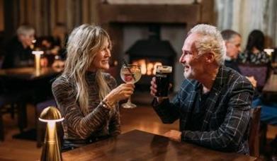 A woman and a man sitting at a table enjoying a G&T and a Guinness at The Valley Hotel.