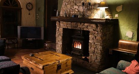 Cosy living room with stone fireplace and burner