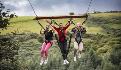 3 girls on a Giant Swing over treetops at Todds Leap