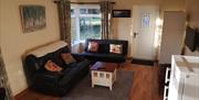 living area with 2 black 2 seater sofas and TV
