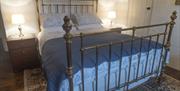 double bed with bedside lockers and blue and white linen