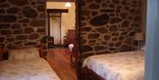 triple room with 1 double bed and 1 single bed and stone walls
