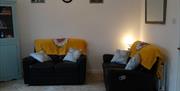 living area with 2 black 2 seater sofas