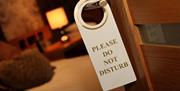 'Please do not disturb' sign hanging on door handle to bedroom