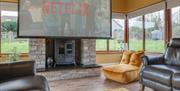 Large cinematic screen that rolls down in a sunroom above the stone fireplace