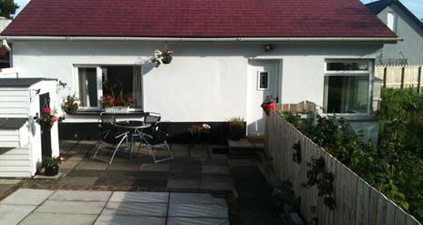 Outside view of Ronan Cottage with table and chairs