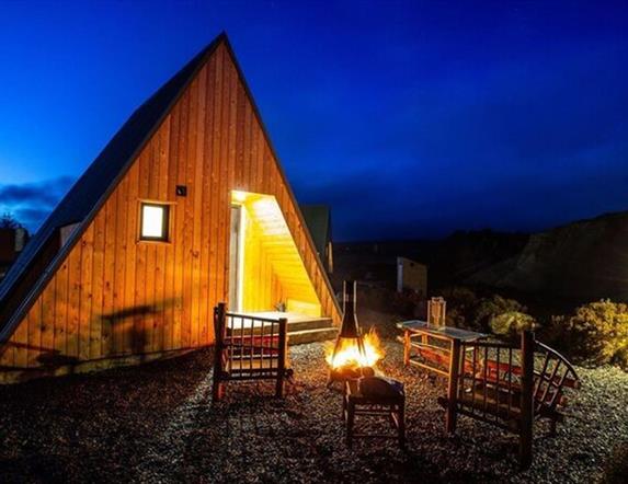firepit and 2 chairs outside glamping pod