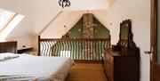 Mezzanine bedroom with double bed and wooden dresser