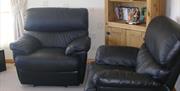 2 black leather armchairs in living area