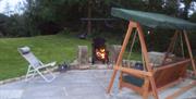 Outside patio area with firepit and wooden swing chair