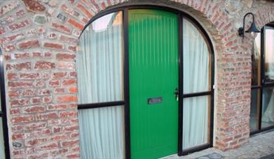 A green door in a arch way 