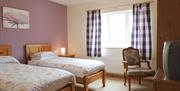 Twin room with 2 single beds and a chair