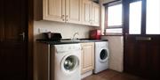 Image of the utility room featuring a washing machine and tumble dryer