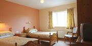 Twin room with 2 single beds and a chair