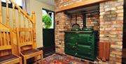 Large green range cooker with brick surround