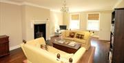 Living area with 2 white 2 seater sofas, fireplace and TV