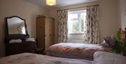 twin bedroom with 2 single beds, mirror and wardrobe