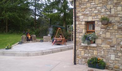 Outside patio area with firepit and wooden chair