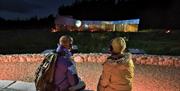 A couple with headphones watching the outdoor projection of the moon