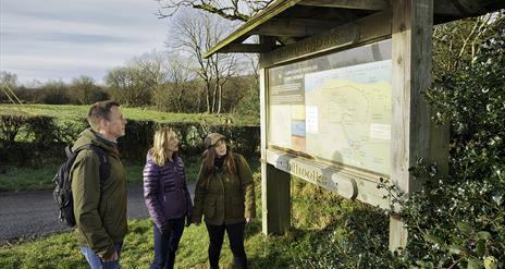 A group looking at signage at the start of Carntogher Heritage Trail
