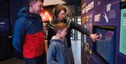 Family using interactive exhibition at OM Observatory