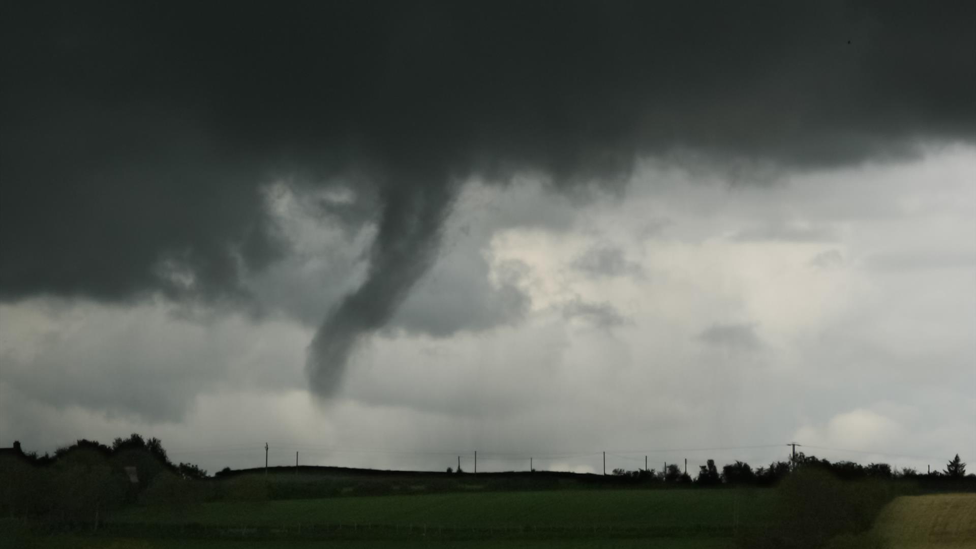 A funnel cloud in a stormy grey sky