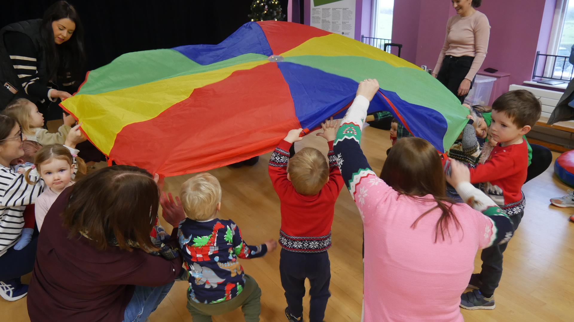 Image of kids playing with a colourful tarp
