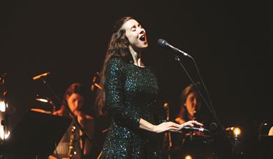 Photo of Lisa Hannigan singing in to a mic