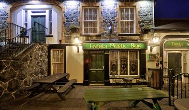 Night-time view of the entrance to Friels Bar