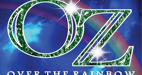OZ written in sparkly green lettering on a blue background