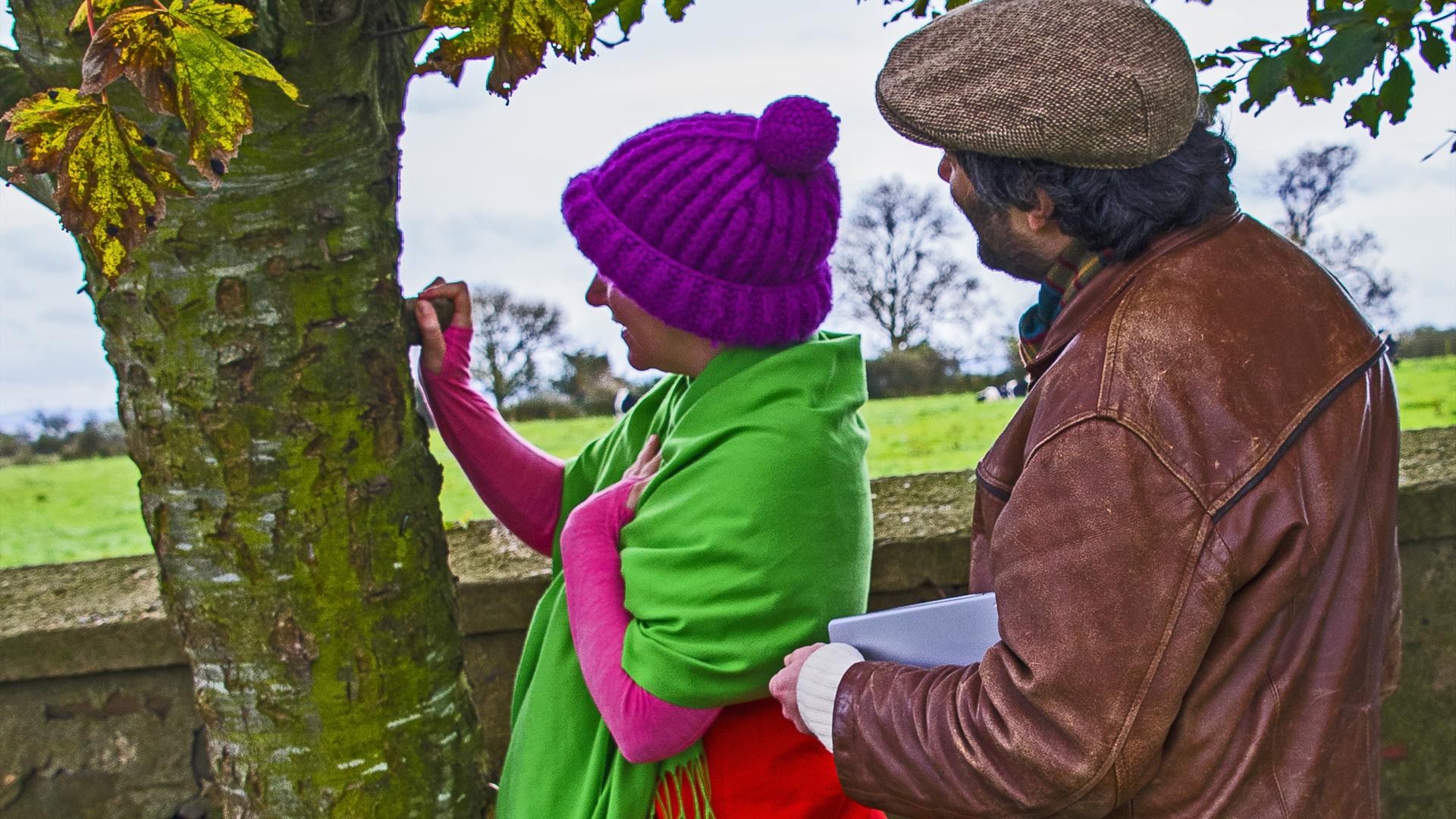 Brightly dressed lady and gentleman looking at tree