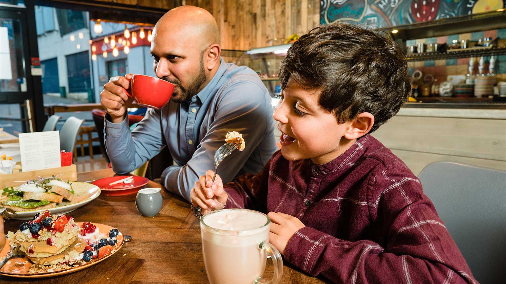 A father and son drinking hot chocolate in a restaurant