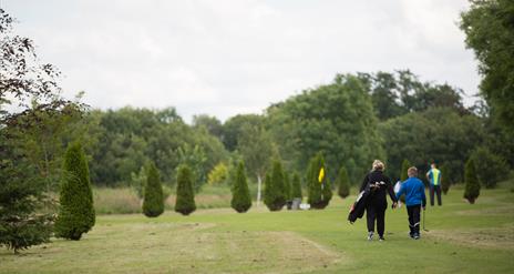 Two people walking on the golf course
