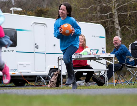 Family of four enjoying at snack outside their caravan