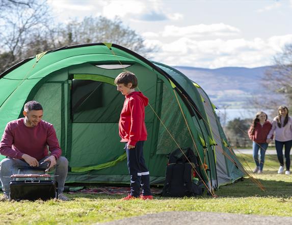 Family enjoying a BBQ infront of their tent in Kilbroney Park