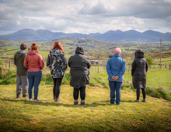 Large group enjoying the Red kite Tour. Ladies wrapped up warm looking out at the Mourne skyline. The view from Lighthouse road car park.